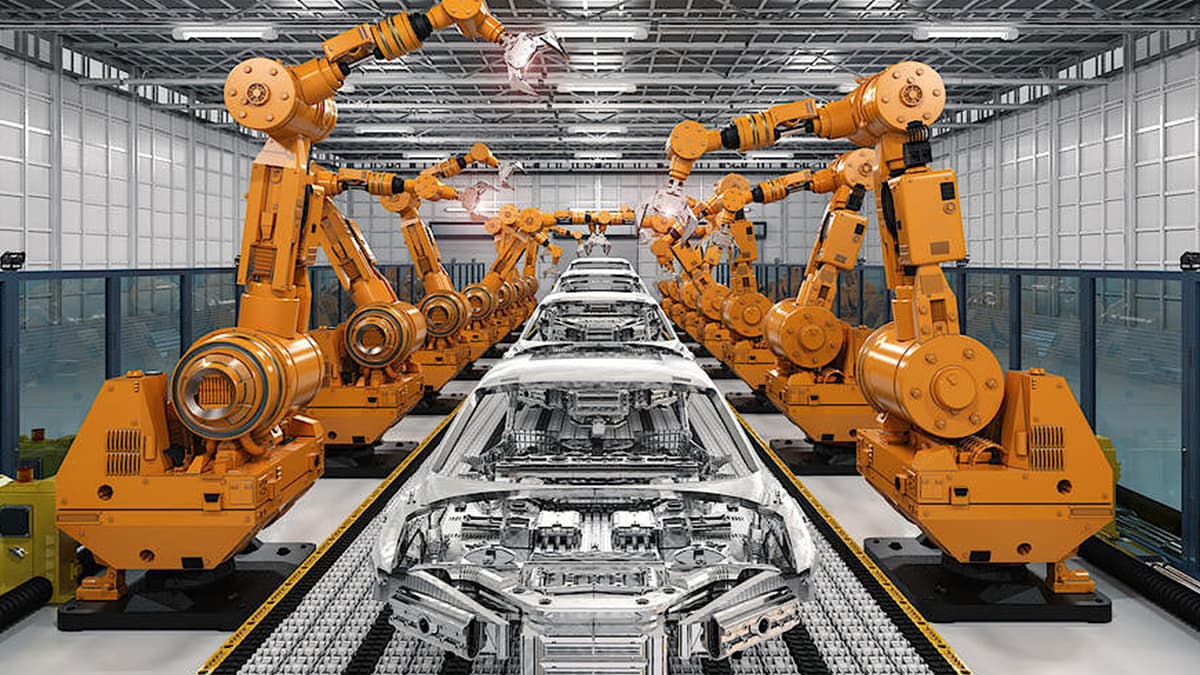 Orange robotic arms on an automotive assembly line